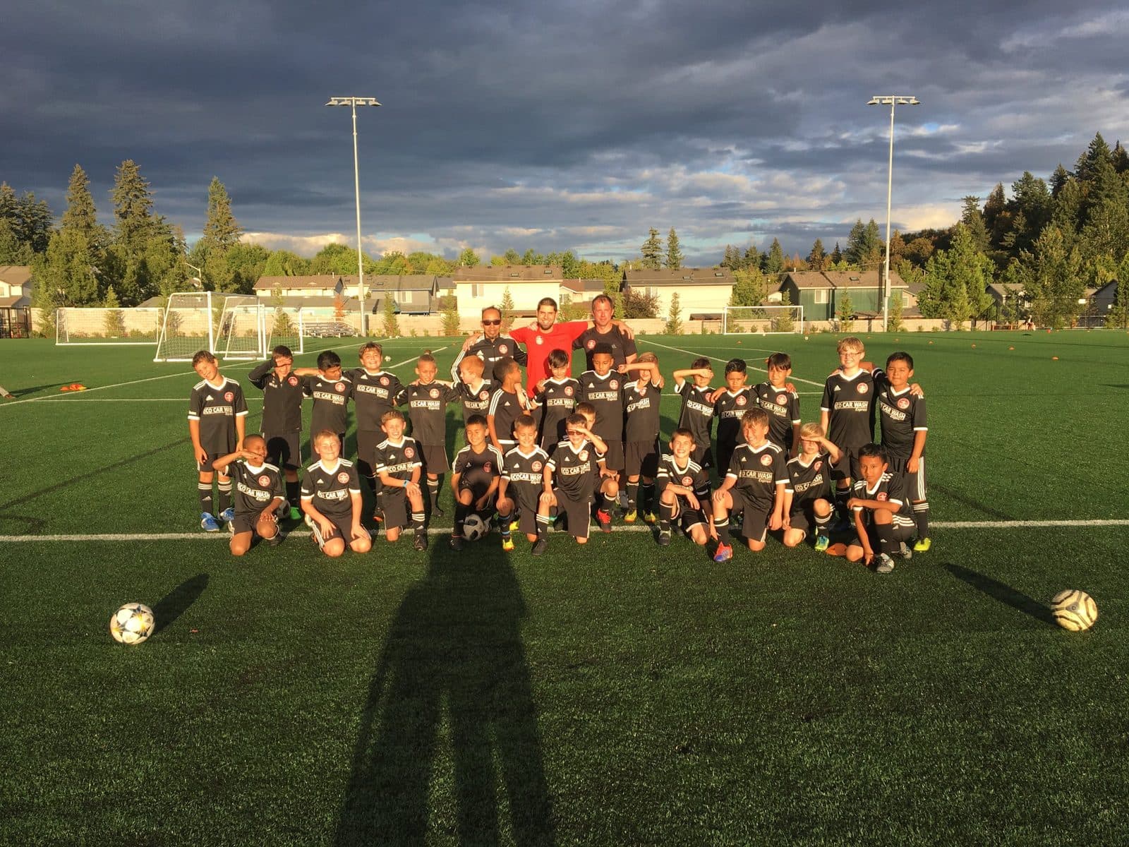 Youth players and coaches together on the turf