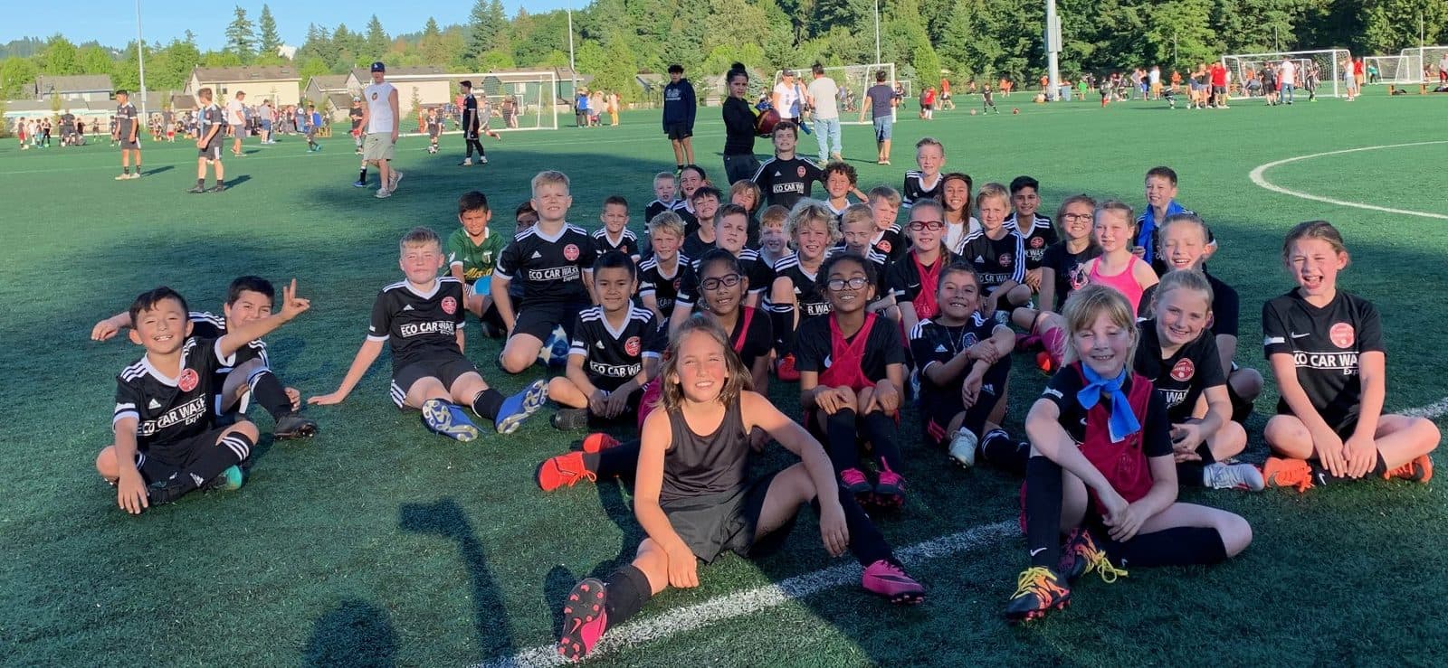 A large group of young players gathered on the turf